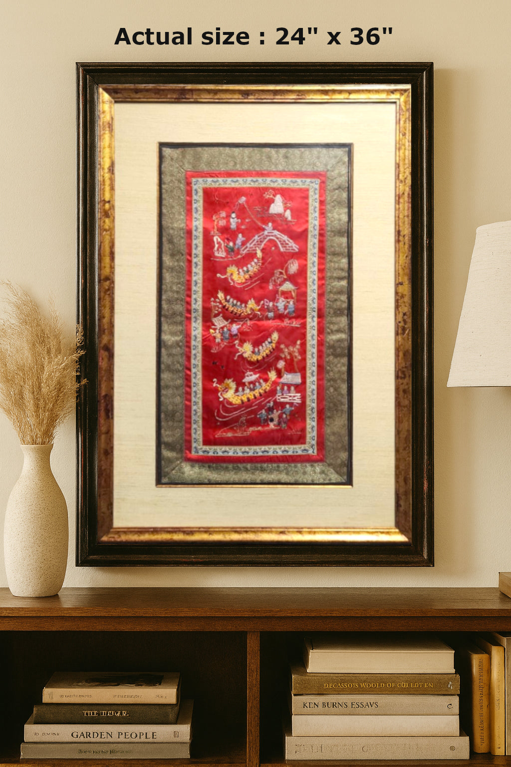 Framed artwork on a wall with books and decor items below