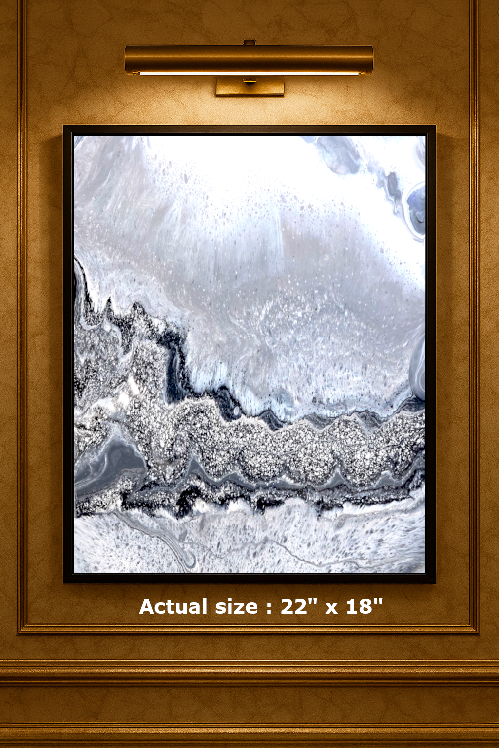 Framed abstract art piece with a gold frame and light fixture above, showing actual size text.
